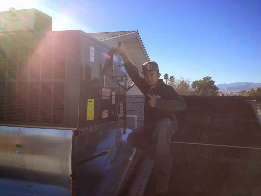 HVAC technician performing AC Tune-Up on a rooftop unit in Bainbridge